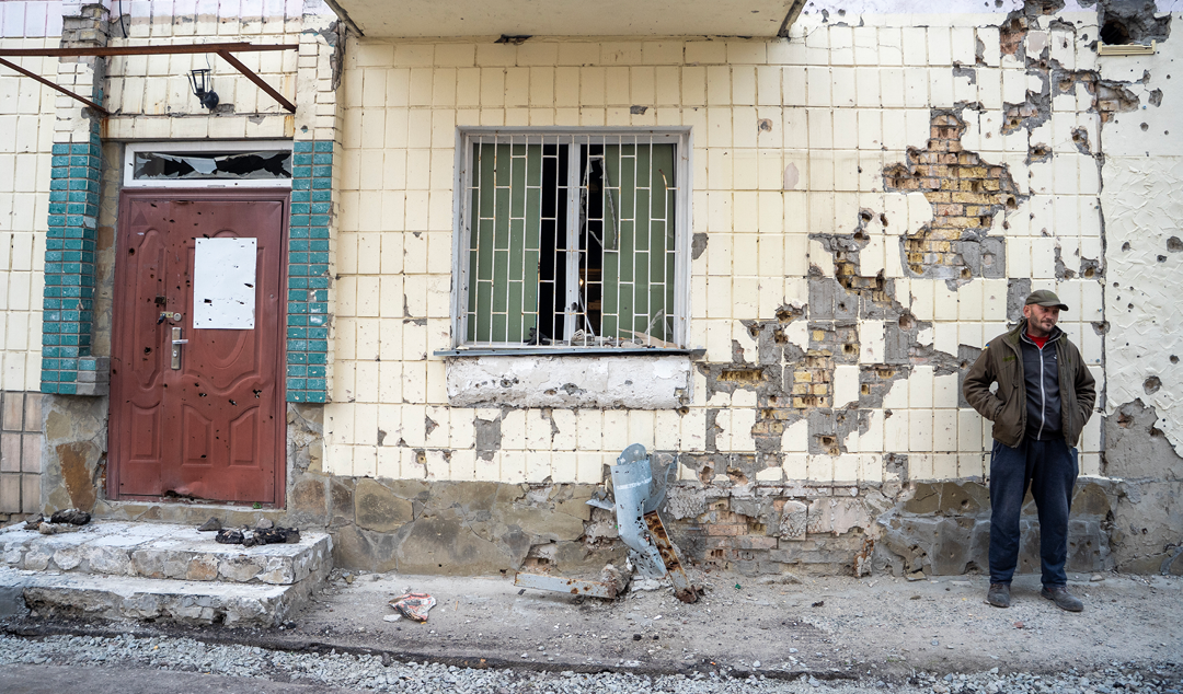 man standing in front of a crumbling wall