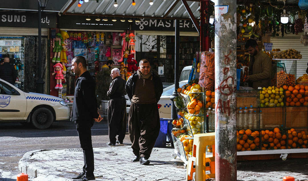 man walking down a street next to a market