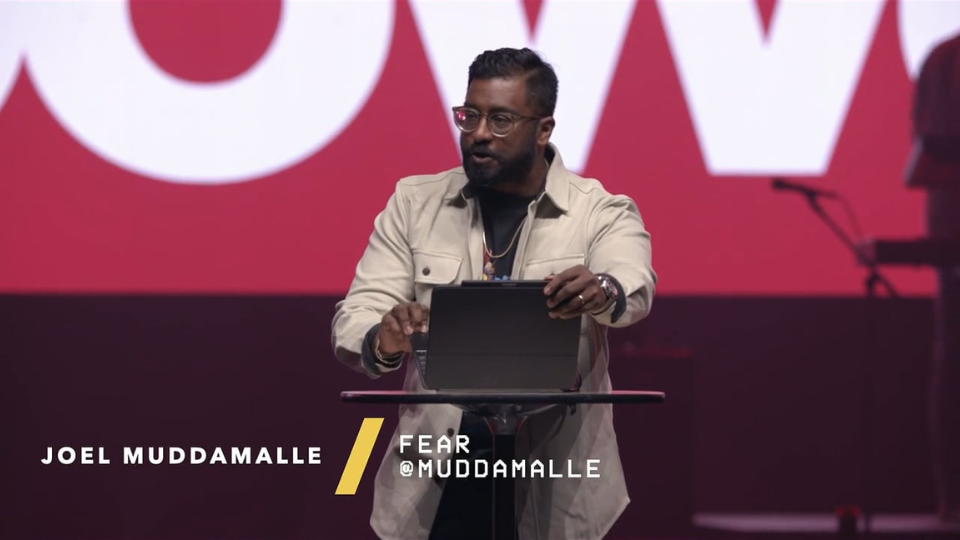 Joel Muddamalle speaking on stage
