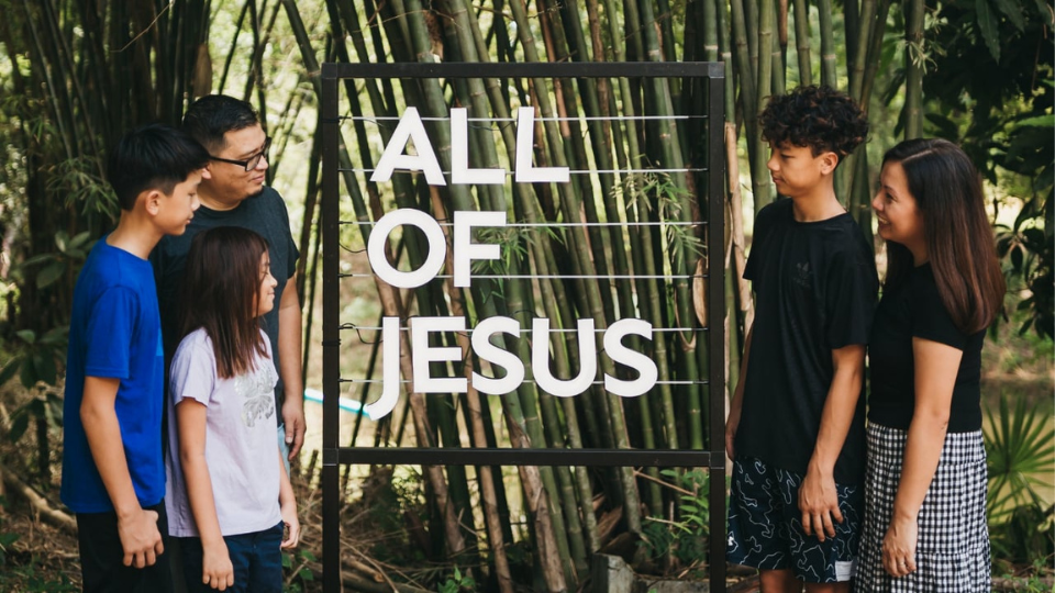 family looking at the All of Jesus sign