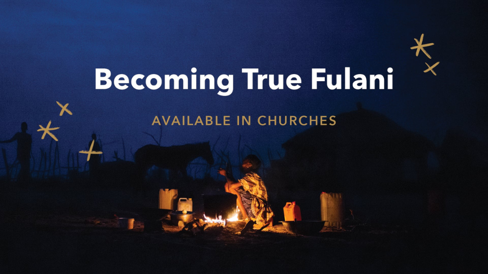 Person sitting by a fire at night in a rural setting with huts and a horse in the background; text reads “Becoming True Fulani – Available in Churches.”