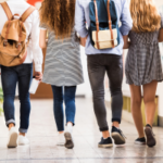 high schoolers walking down a hallway