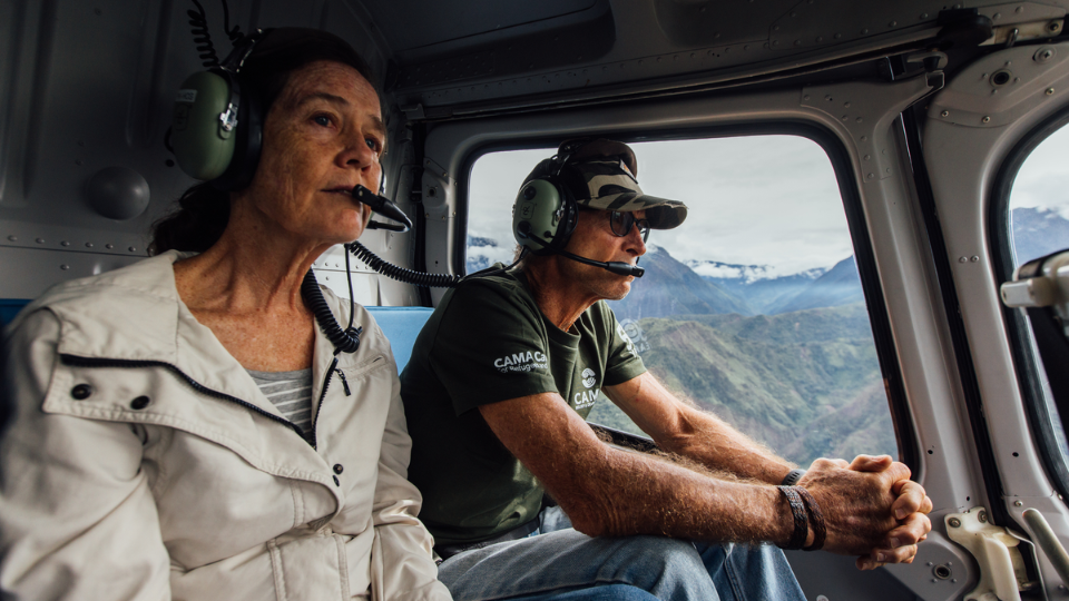 man and women riding in a helicopter with headsets on